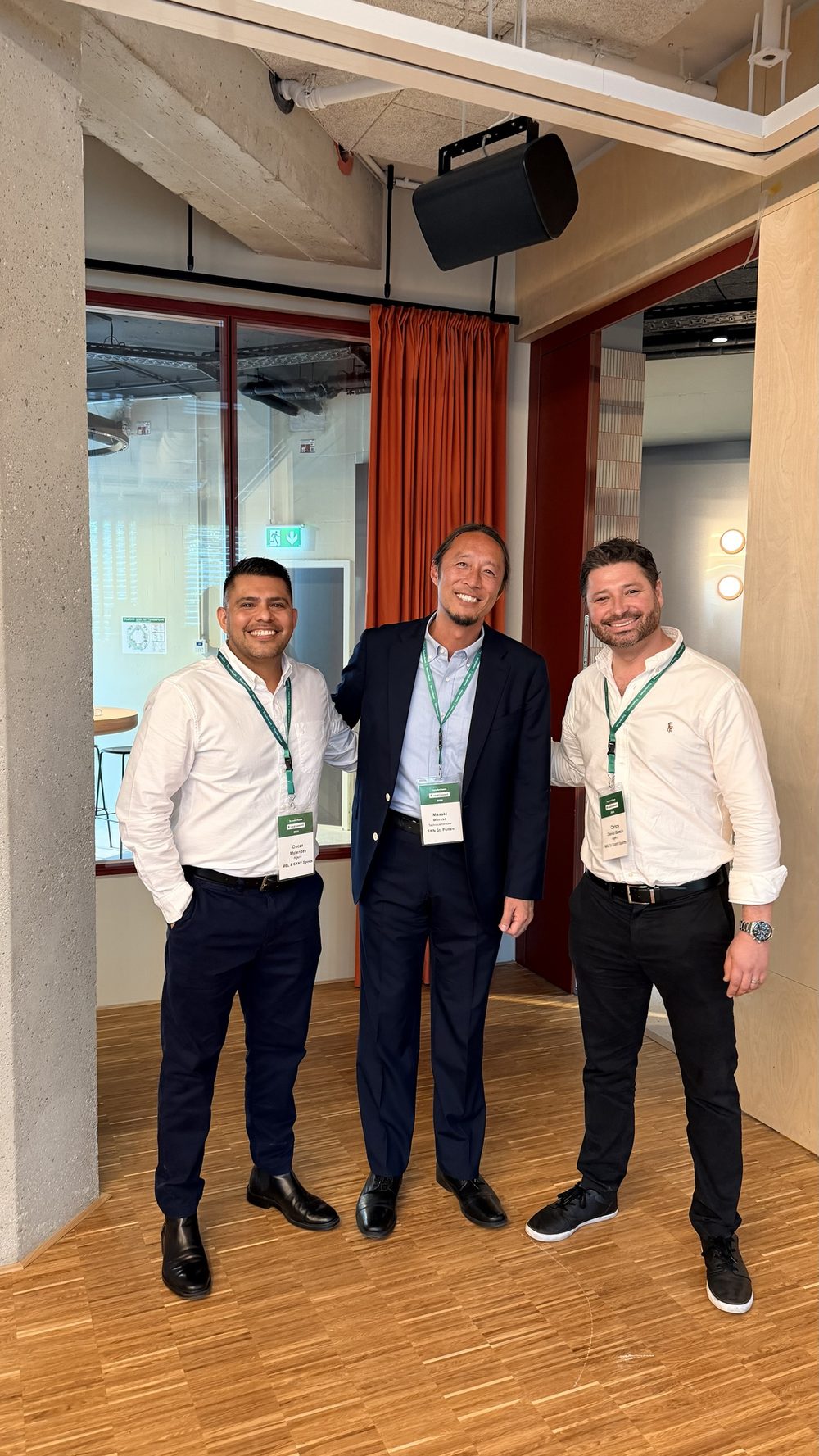 Three men with TransferRoom event badges standing together indoors